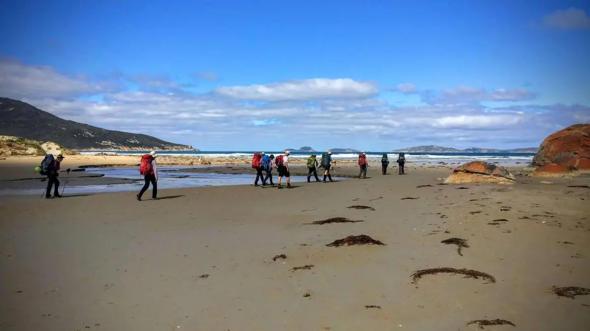 People walking along a wide beach at Wilsons Promontory