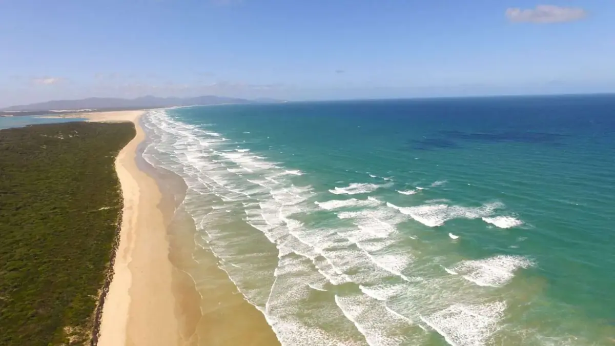Aerial view of waves rolling onto the beach at Sandy Point
